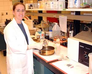 Susan Heyel in a lab in front of equipment.